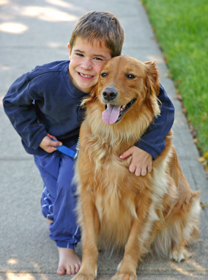 Boy hugging dog.